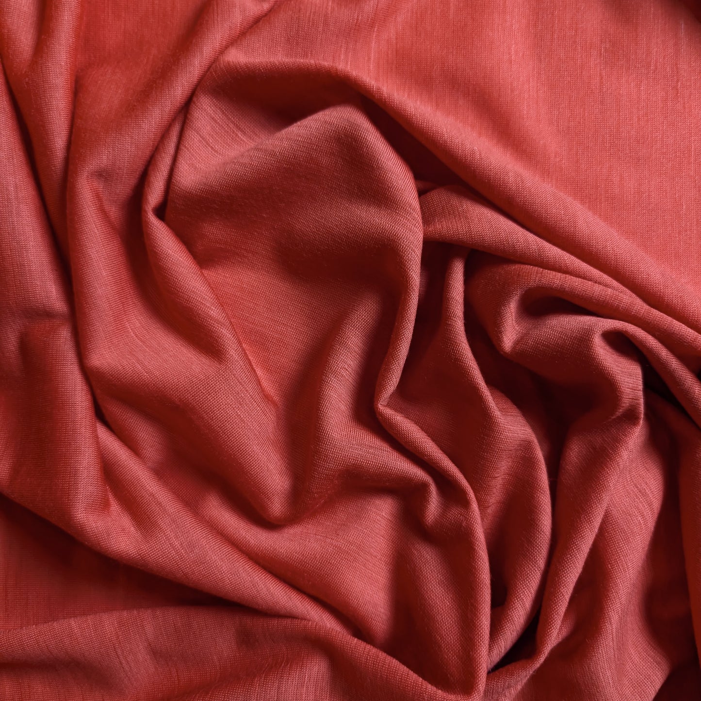 Soft, draped coral wool jersey fabric, 130cm wide, ideal for clothing.
