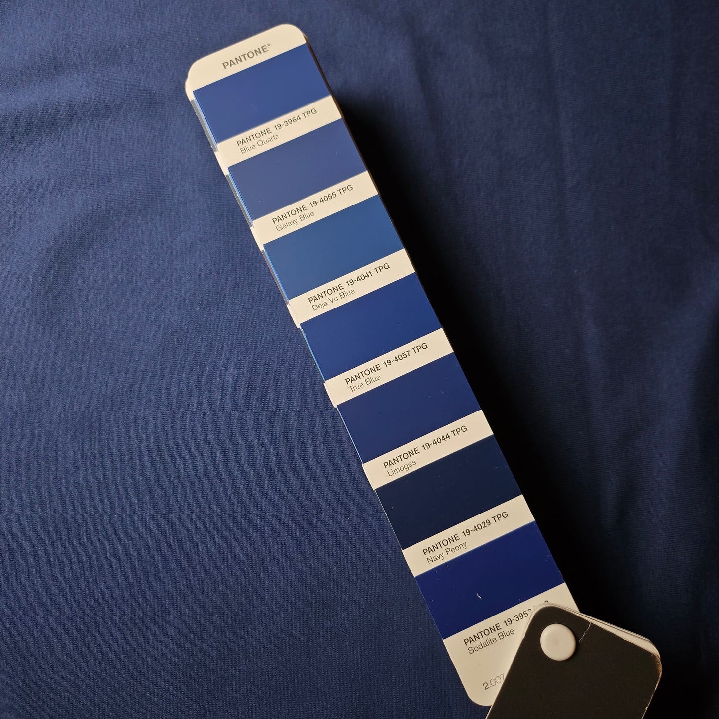 Galaxy Blue LW Ribstrick fabric swatch, a lightweight blue tubular knit, shown with a Pantone color guide.