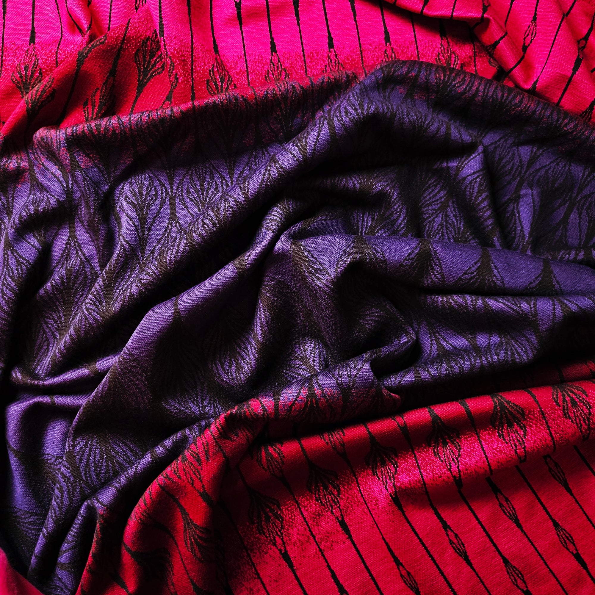 Soft, elastic deadstock jersey cotton blend fabric with a pink-purple gradient and dark abstract patterns.