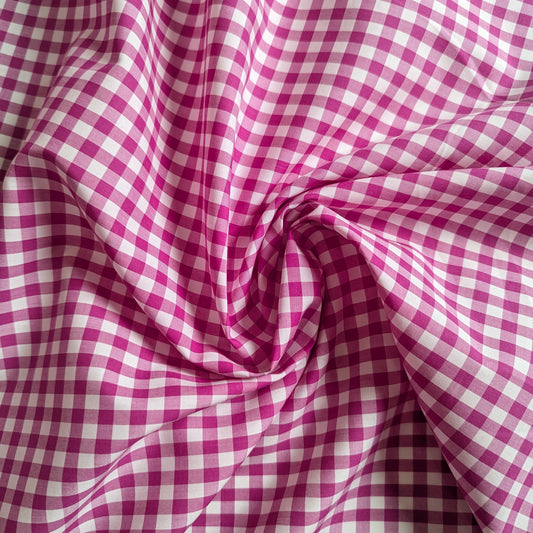 Magenta and white gingham cotton poplin fabric, 145 cm wide, with a swirled fold.