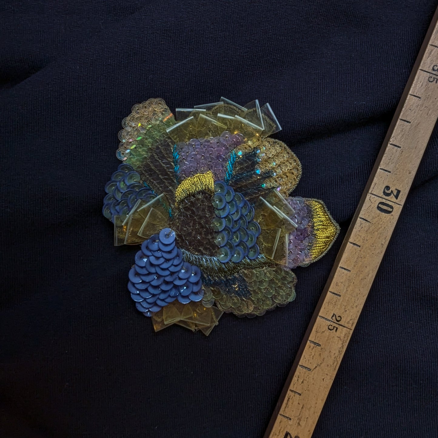 D&G floral patch with blue, green, and gold sequins, embroidery, and textile details.