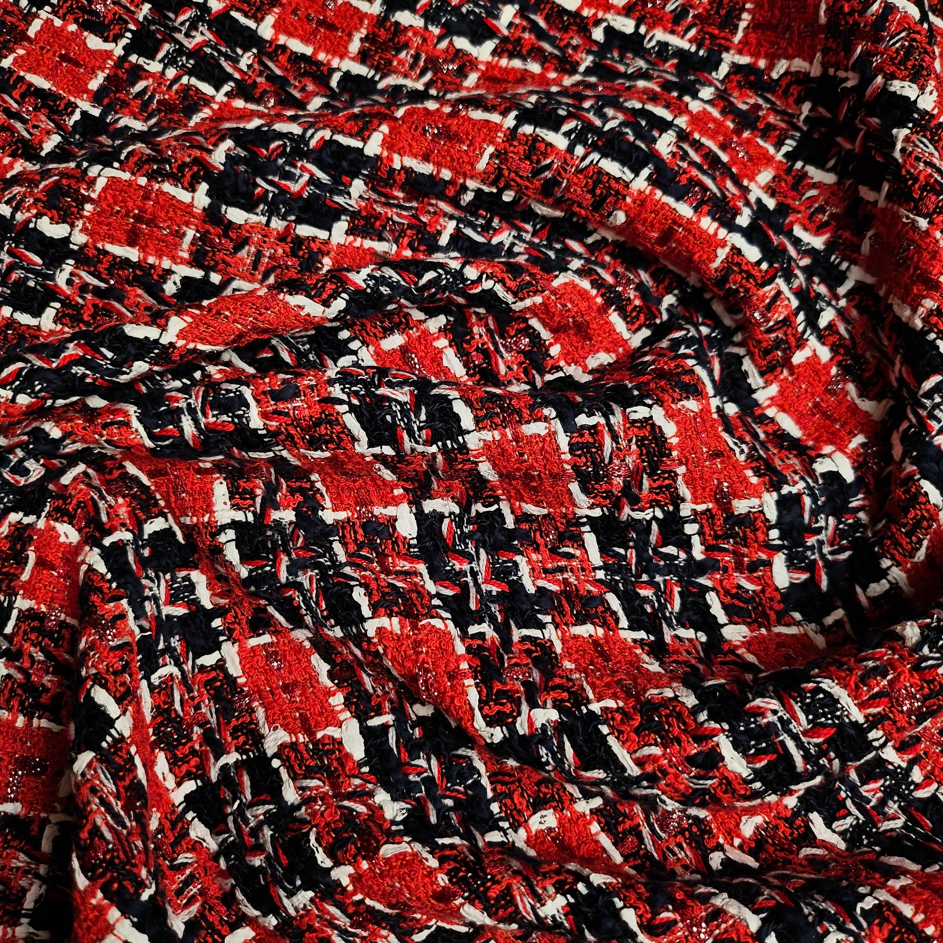 Red, black, and white tweed fabric with a textured weave, suitable for fashion projects.