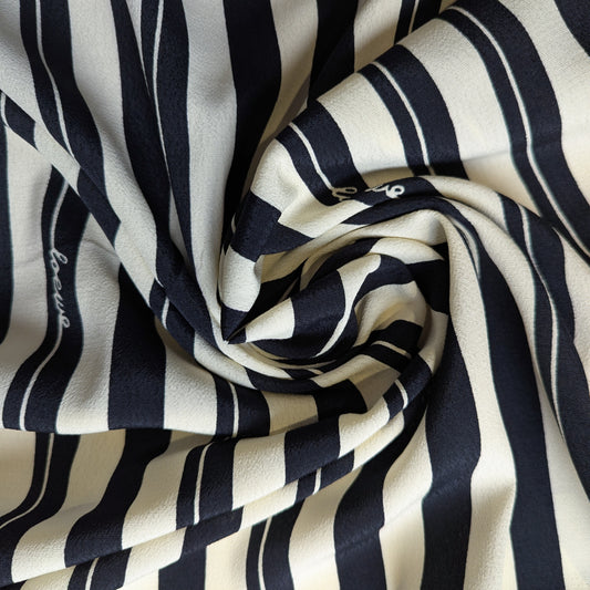 Viskosecrepe fabric, 140cm, with black and natural white vertical stripes, subtly branded.