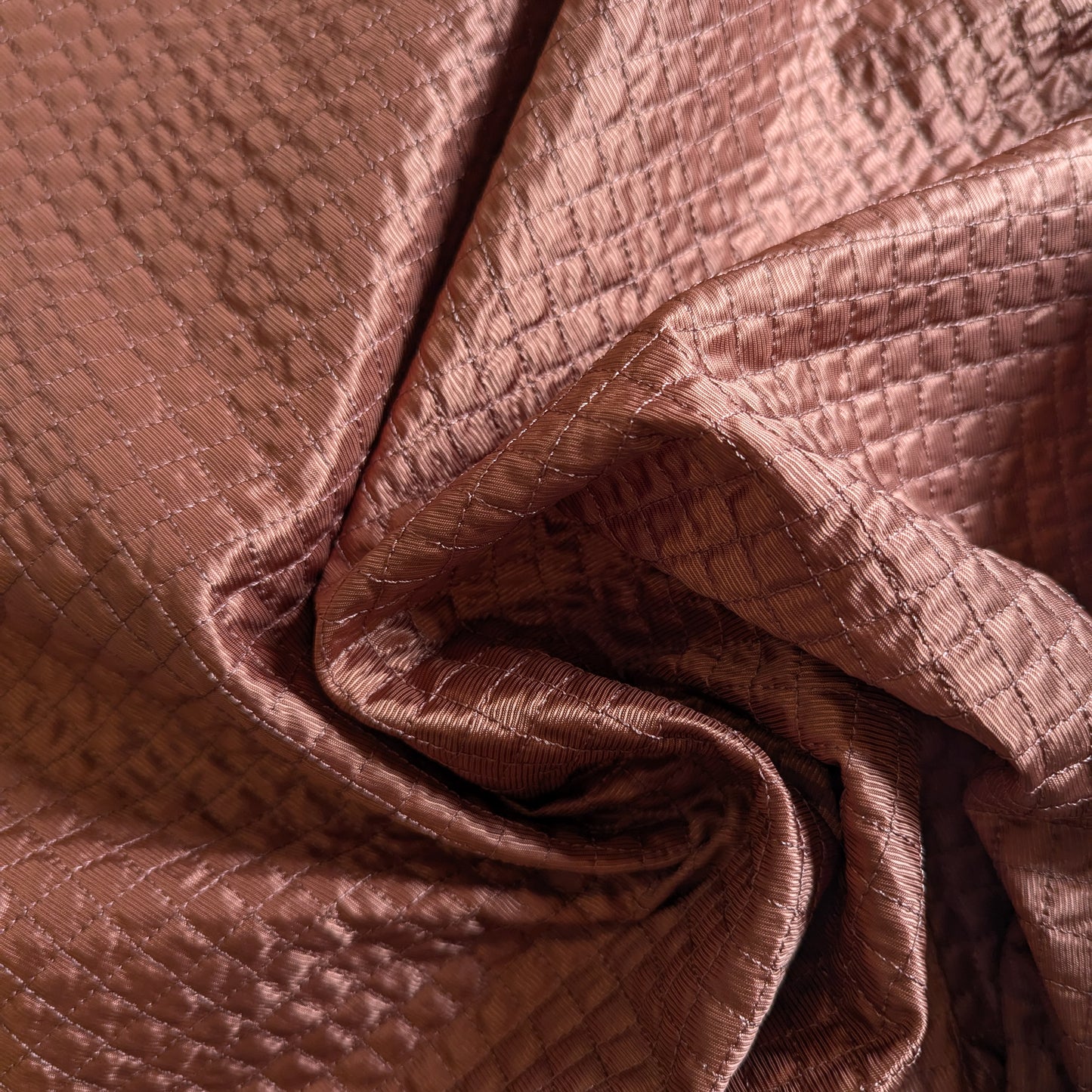 Etruscan Red deadstock quilted fabric, lightly padded with a fine square stitch pattern.