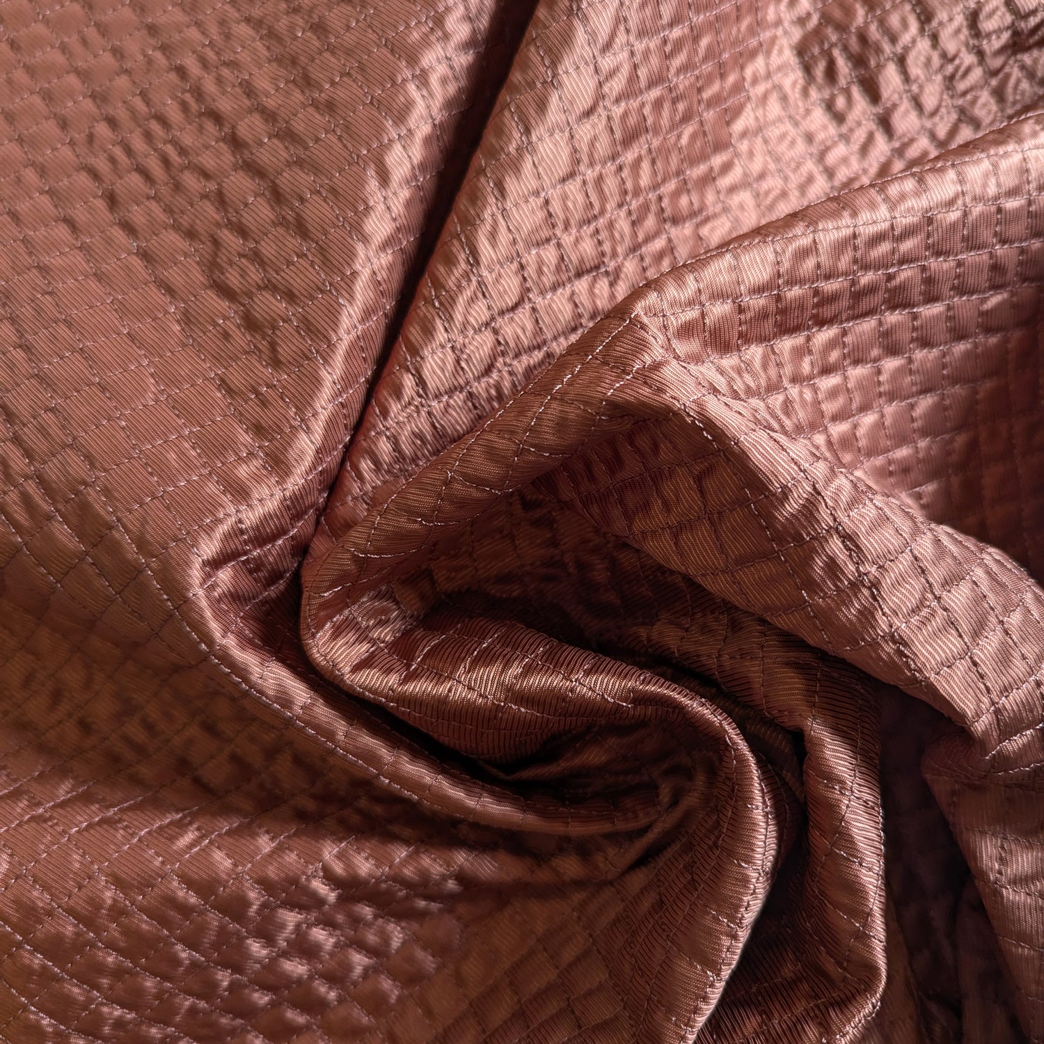 Etruscan Red deadstock quilted fabric, lightly padded with a fine square stitch pattern.