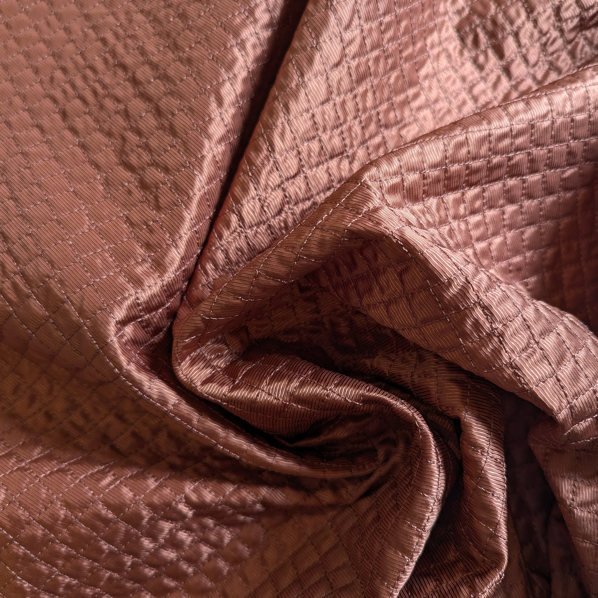 Etruscan Red deadstock quilted fabric, lightly padded with a fine square stitch pattern.