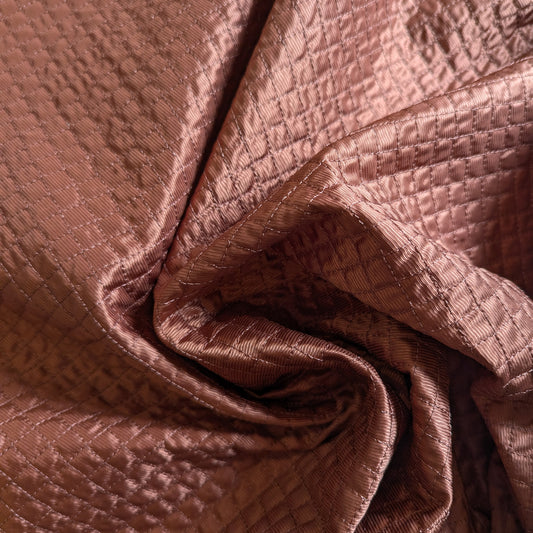 Etruscan Red deadstock quilted fabric, lightly padded with a fine square stitch pattern.