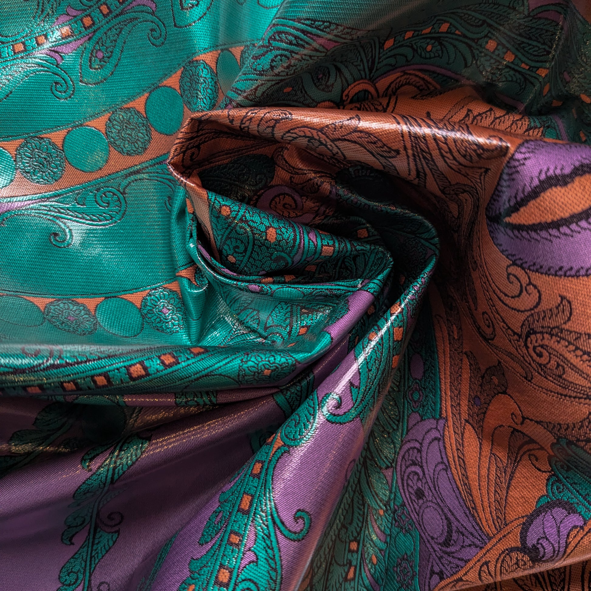 Deadstock polyester fabric, 145cm wide, with a multicolor paisley pattern in teal, purple, and orange.