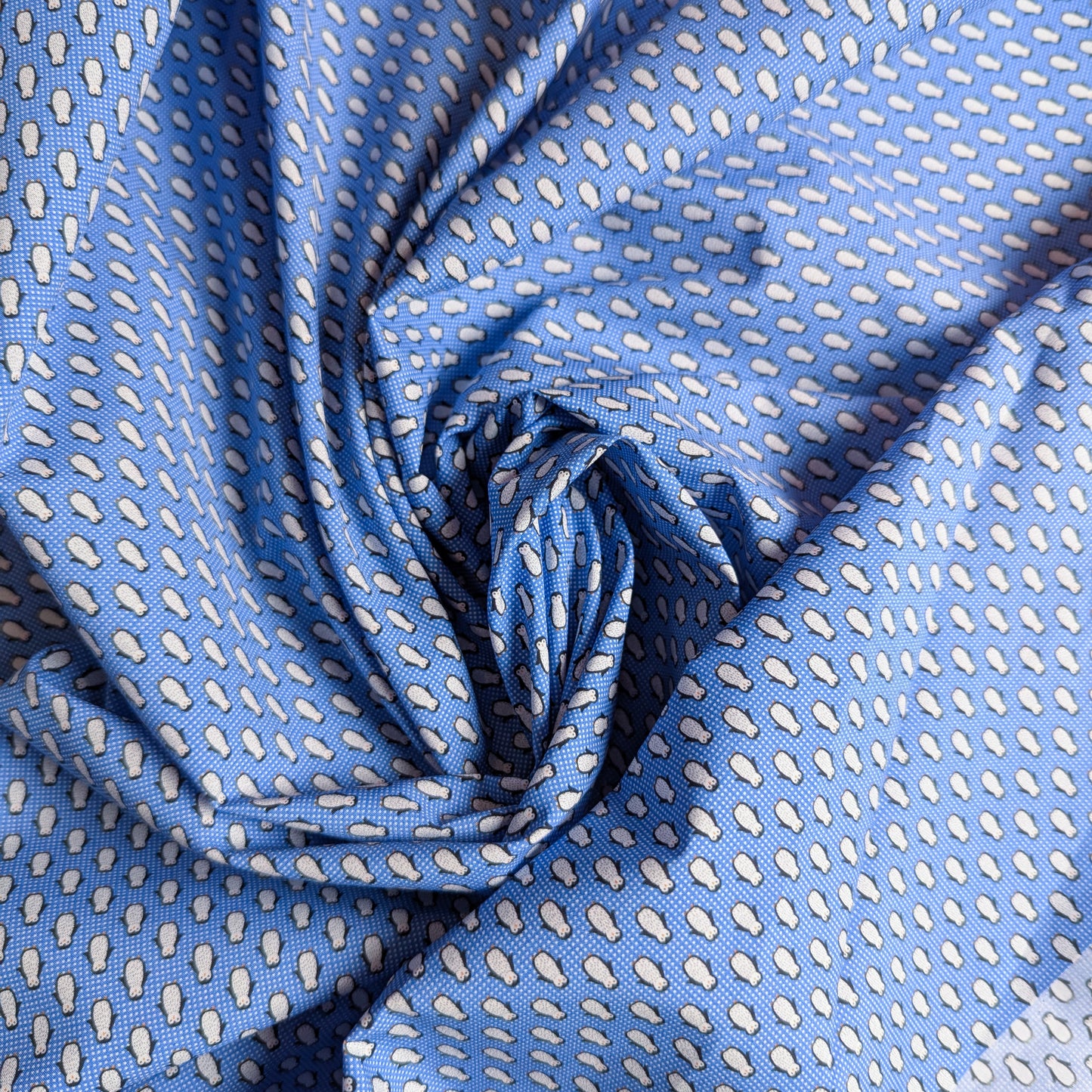 Blue cotton poplin deadstock fabric with a white teardrop pattern, draped in soft folds.