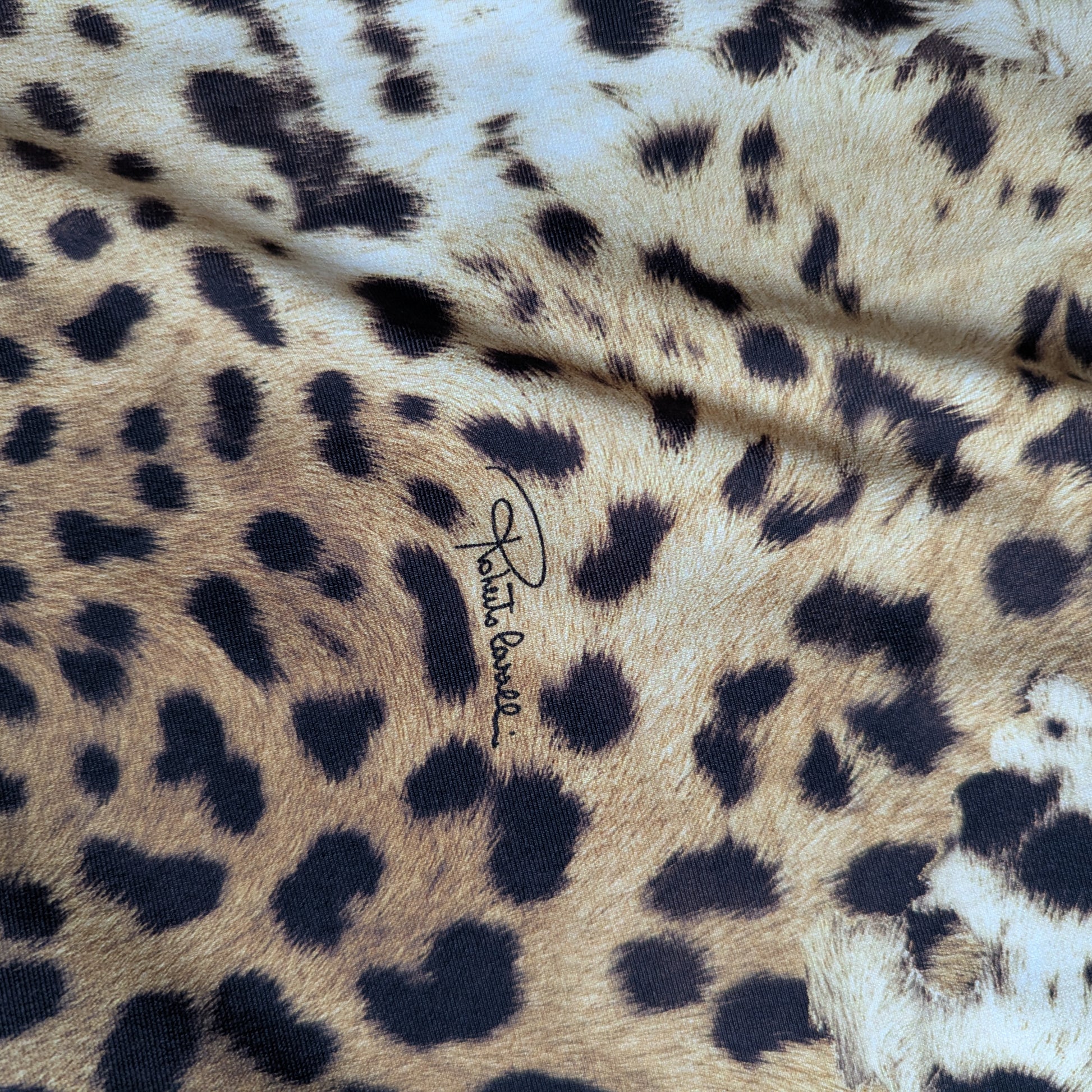 Elastic C*avalli deadstock Lycra fabric with natural leopard print, tan, brown, black spots, and signature logo.