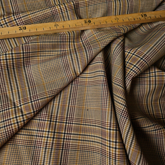 Brown Prince of Wales plaid wool fresco fabric with a wooden ruler showing 145 cm width.