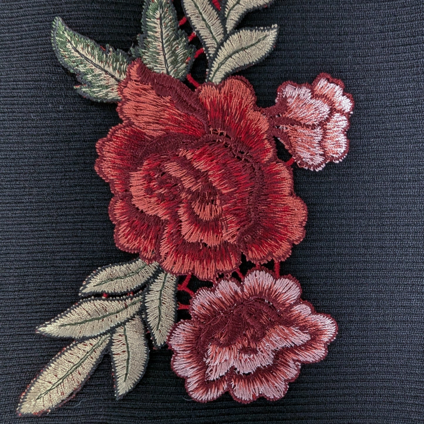 XXL G*cci patch with detailed red rose embroidery and green leaves on a dark fabric.