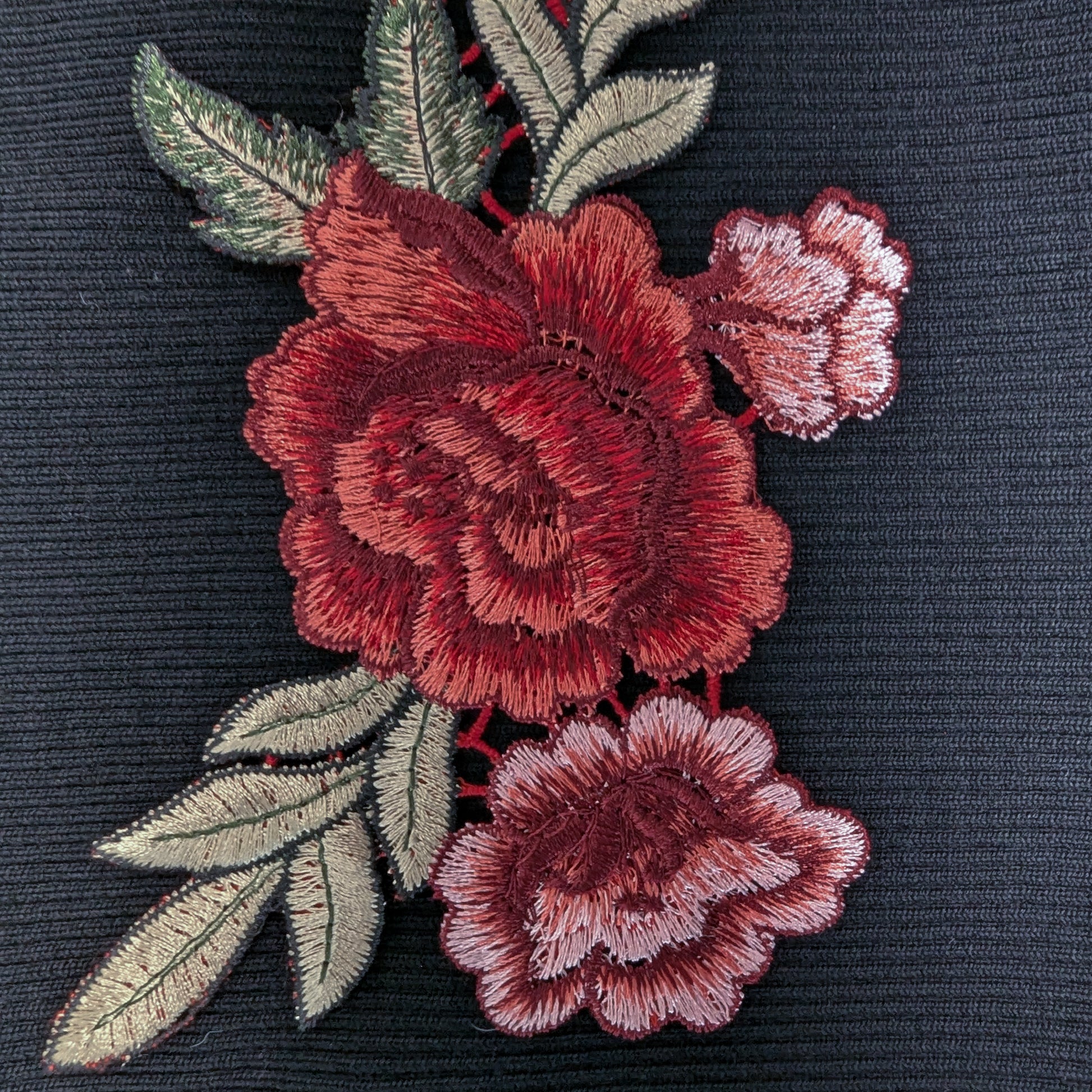 XXL G*cci patch with detailed red rose embroidery and green leaves on a dark fabric.