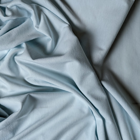 Light blue G*cci deadstock cotton jersey fabric, 165 cm wide, draped with soft folds.