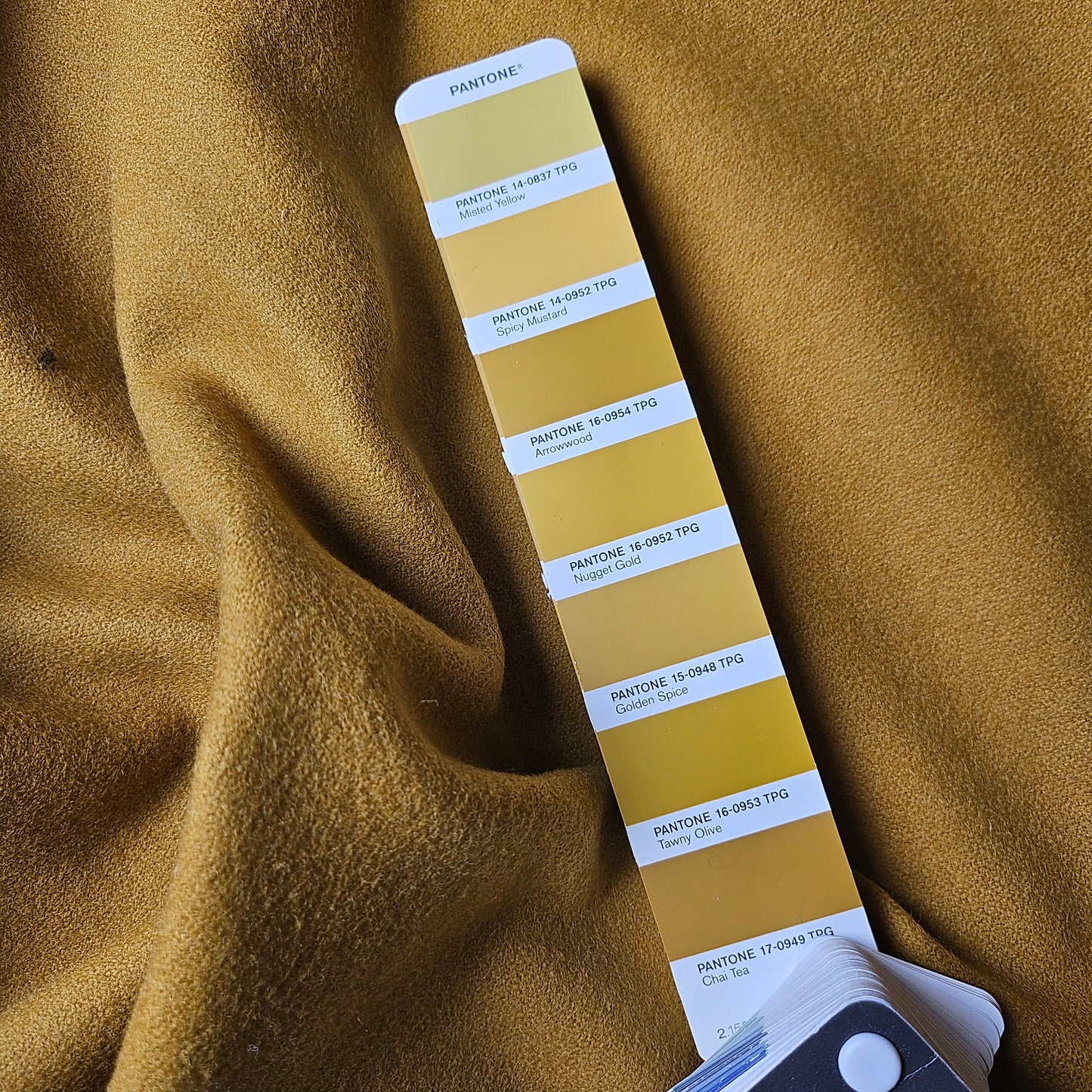 Deadstock Arrowwood Schurwolle fabric, a warm mustard yellow, with a Pantone color swatch showing "Arrowwood".