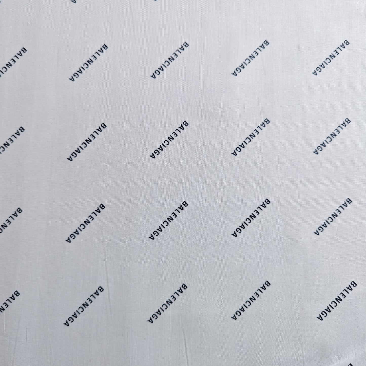 White Balenciaga deadstock cotton poplin fabric with repeated black logo print.