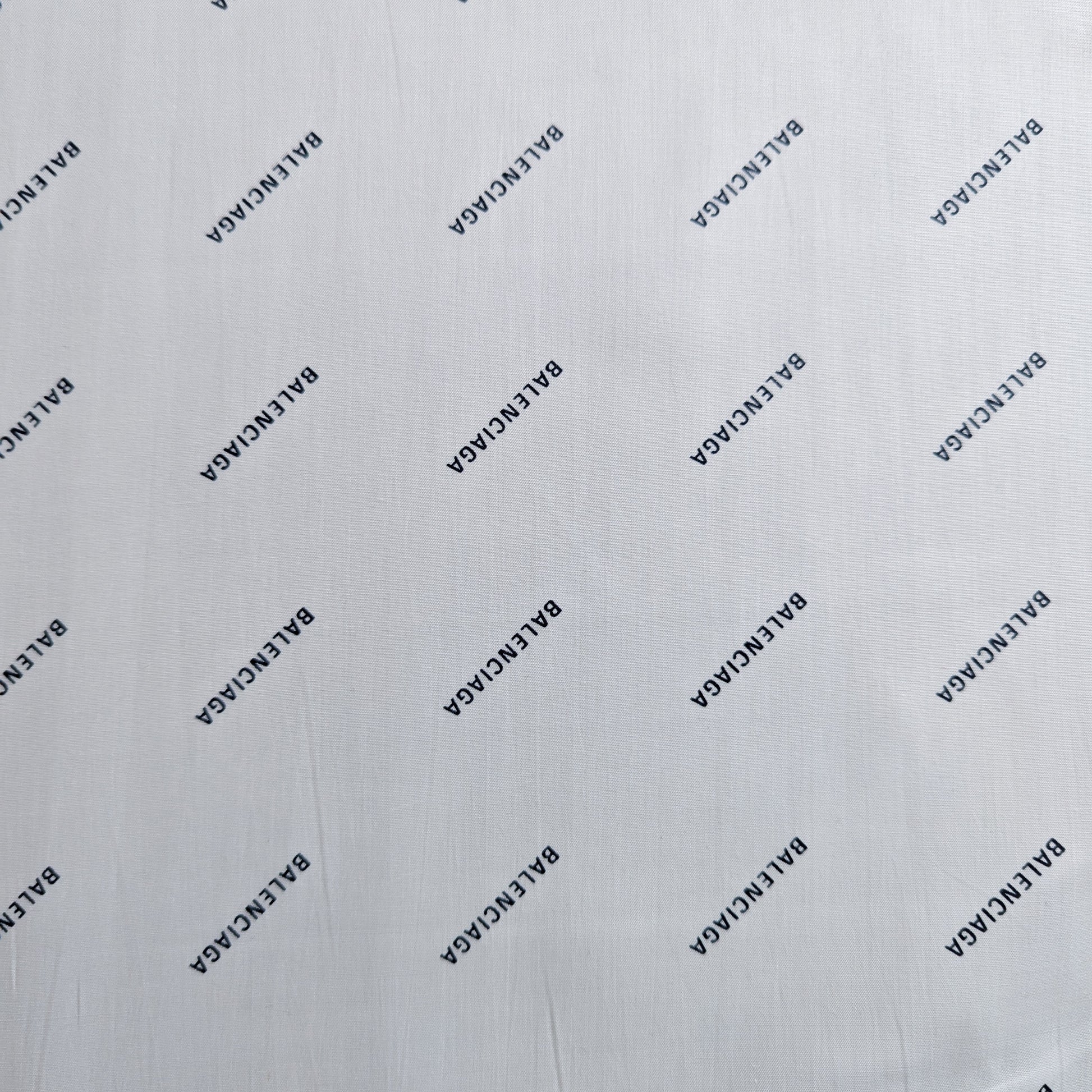 White Balenciaga deadstock cotton poplin fabric with repeated black logo print.