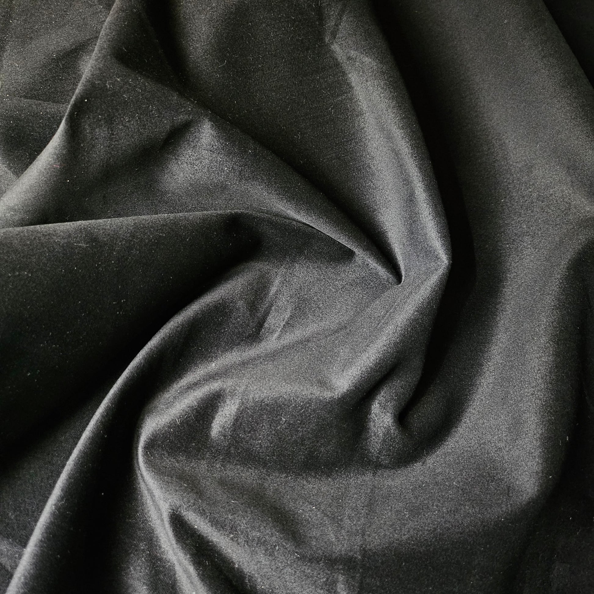 Deadstock black velvet denim fabric, 150cm wide, with soft folds and a subtle sheen.