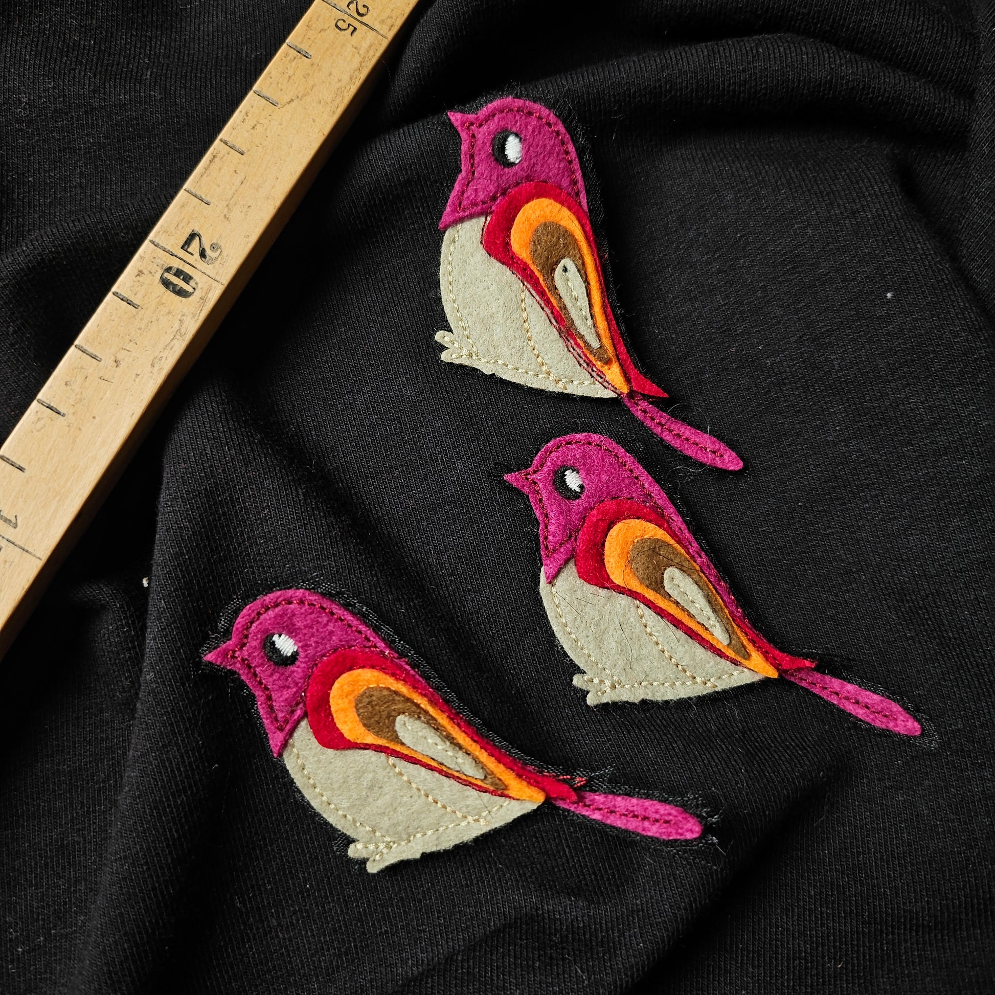 Three colorful D&G bird embroidery patches (5x7cm) in pink, orange, and brown on black fabric.