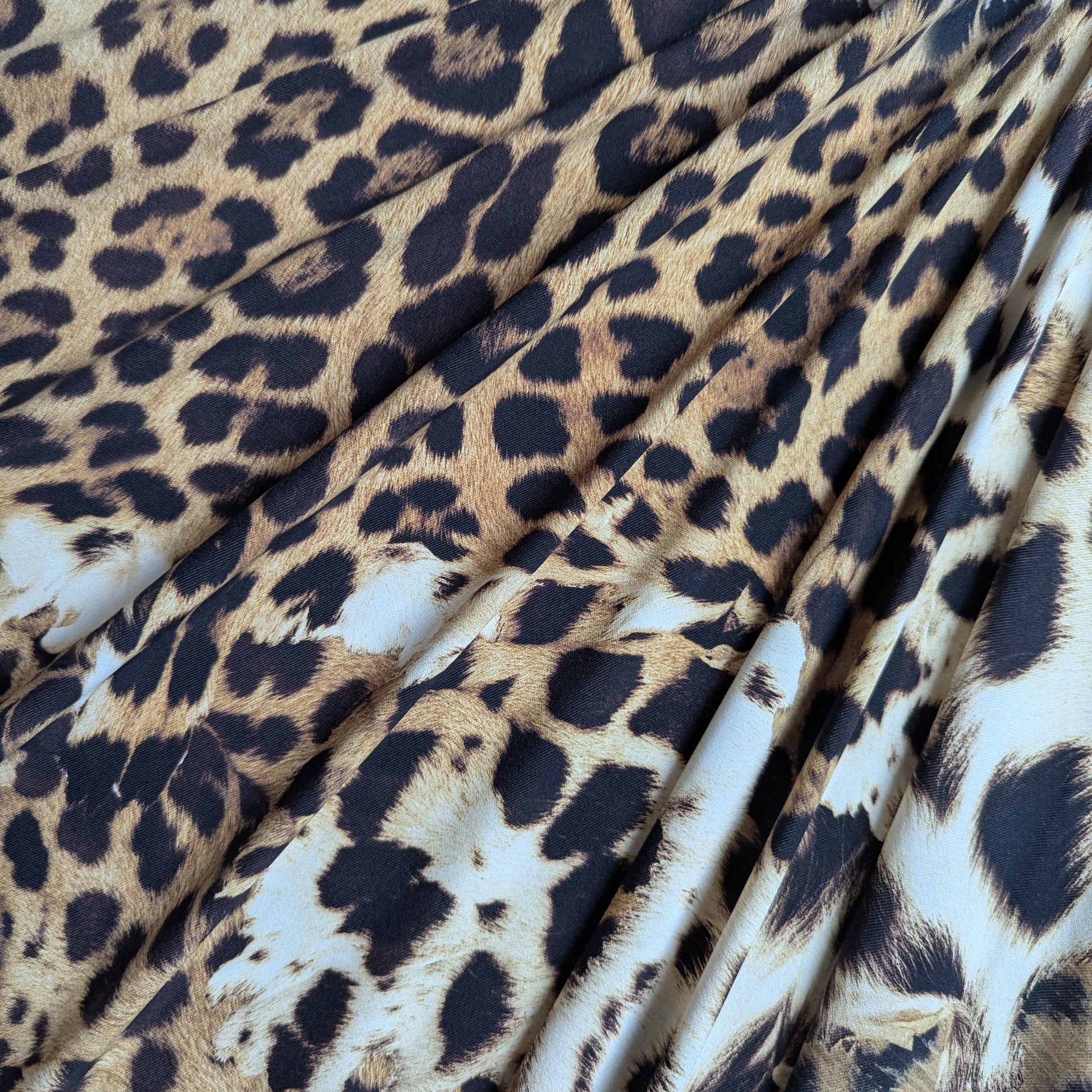 C*avalli deadstock Lycra fabric with classic brown, black, and tan leopard print, showing elastic drape.