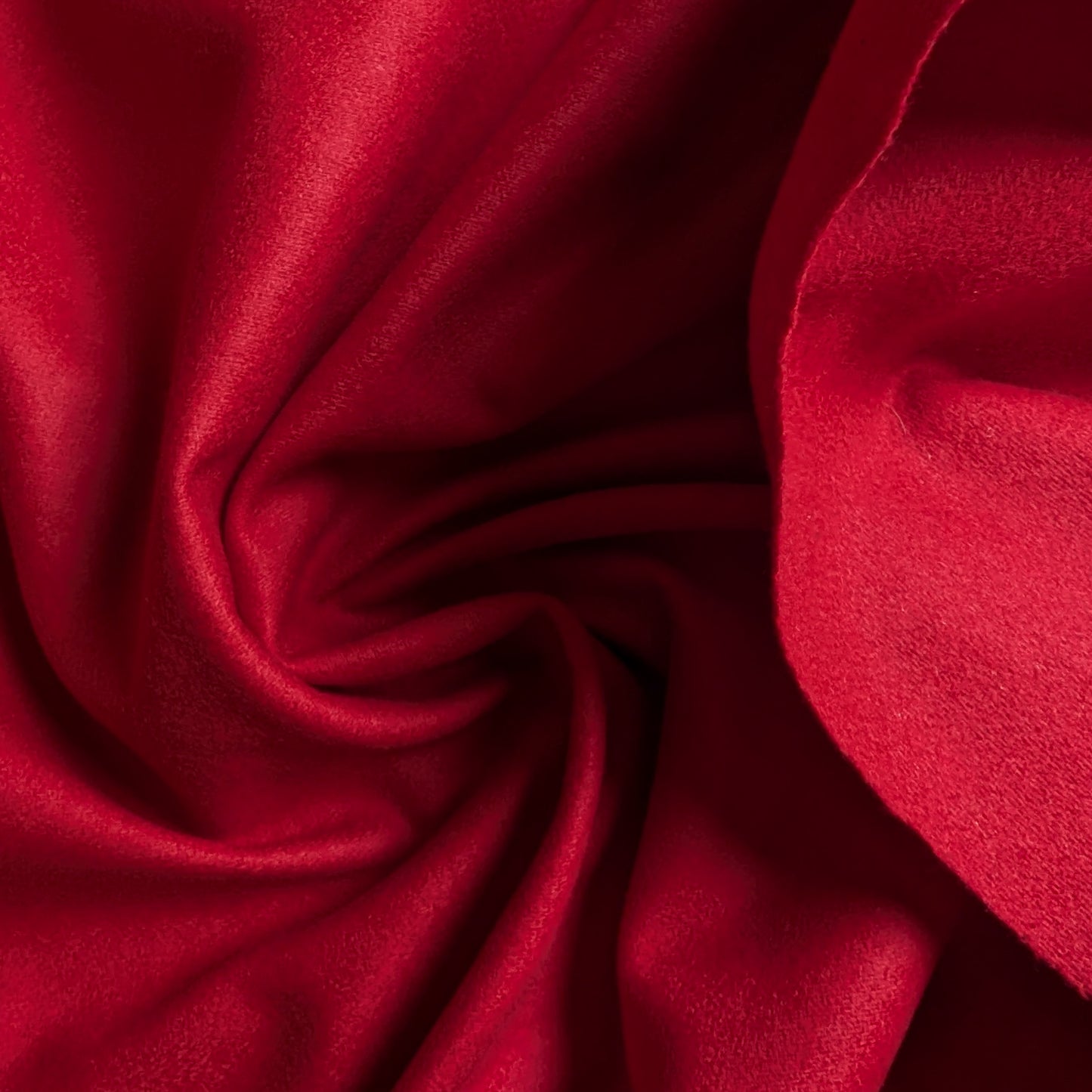 Soft, structured red melange wool fabric, draped with gentle folds and a subtle texture.