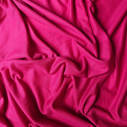 Vibrant fuchsia cotton-cashmere pique fabric, draped with subtle texture.