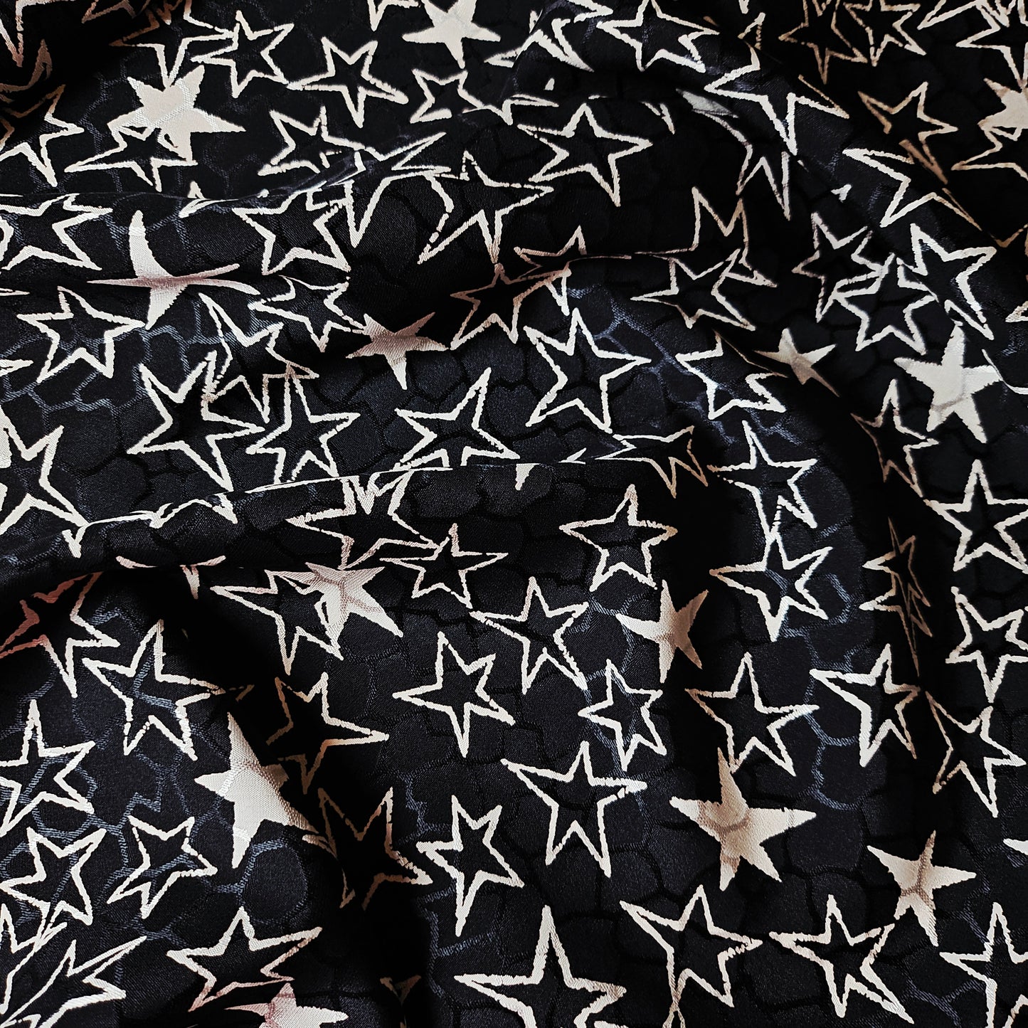 Black and off-white YSL deadstock silk jacquard fabric with a scattered star pattern.