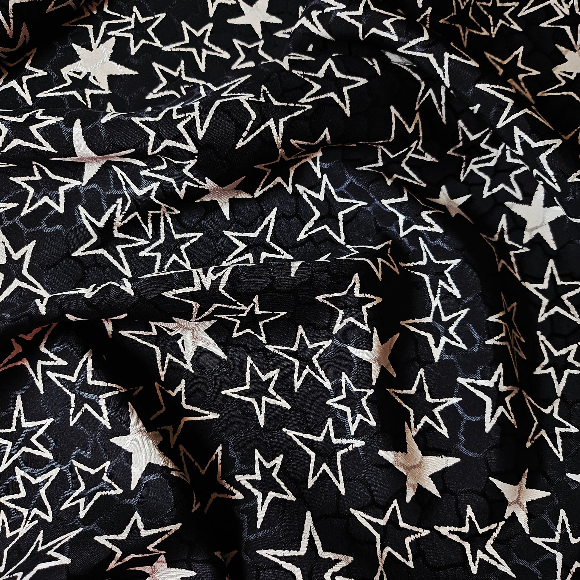 Black and off-white YSL deadstock silk jacquard fabric with a scattered star pattern.