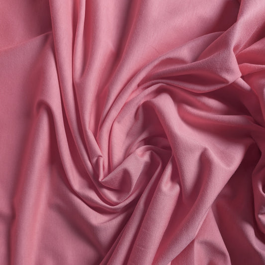 Wolljersey deadstock fabric in a soft, muted pink, draped with gentle folds.