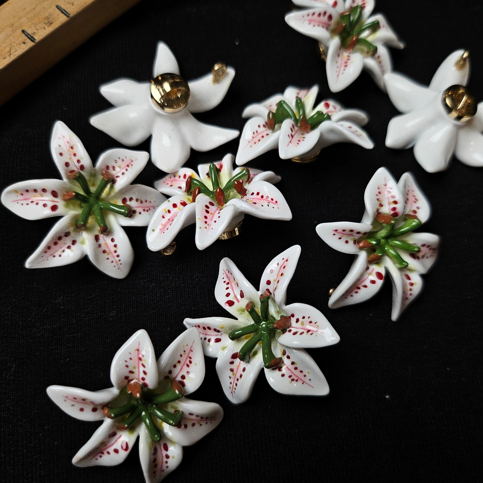 White ceramic flower patches with green stems and red speckles, 3x3 cm.