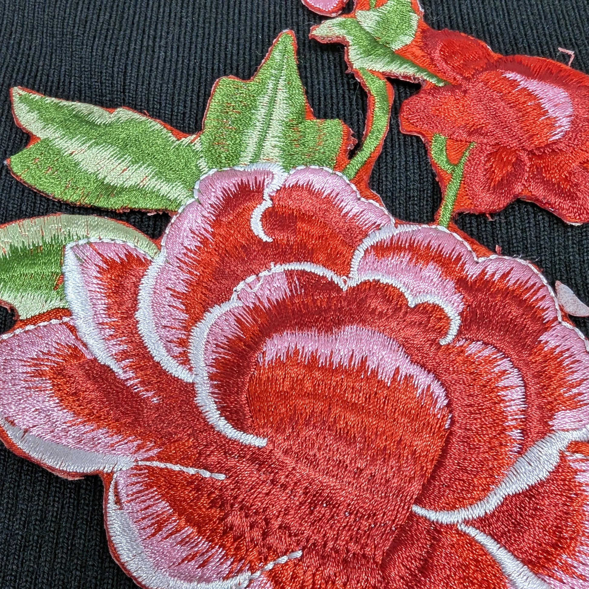 XXL G*cci red and pink rose embroidery patch with green leaves on black fabric.