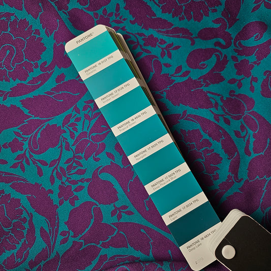 Deadstock designer sweat fabric: tropical green and purple baroque pattern, soft brushed interior, with Pantone swatch.