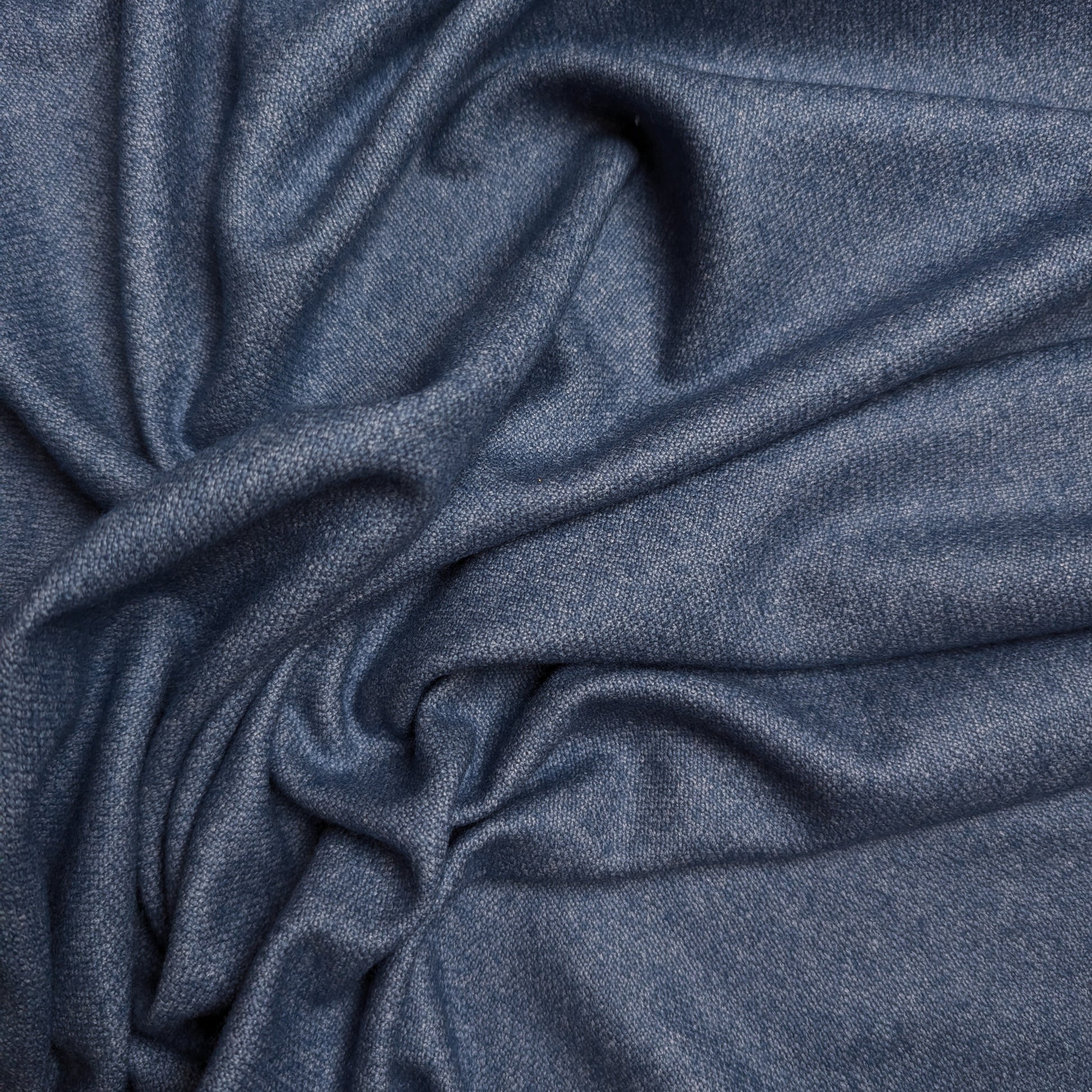 Stonewashed blue wool-cashmere blend deadstock fabric, draped with soft folds.