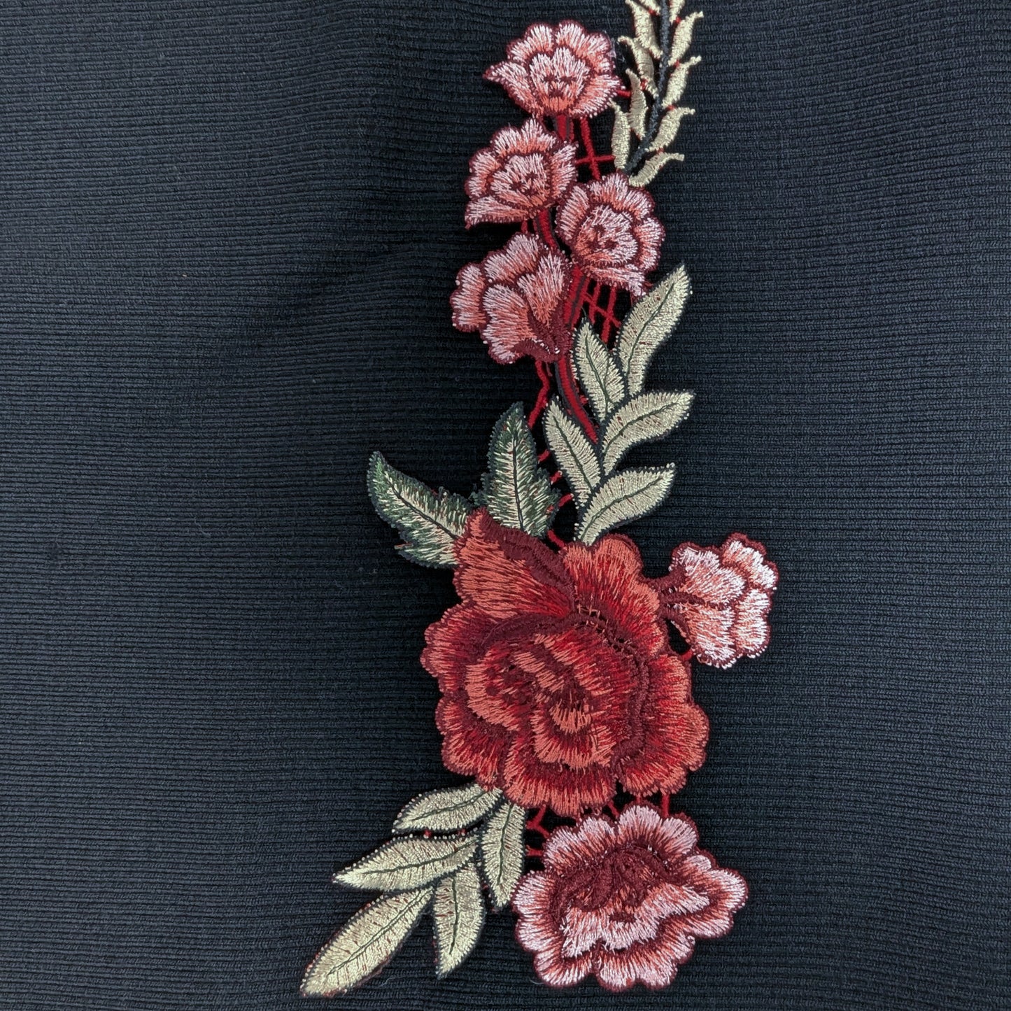 XXL G*cci patch with detailed red rose embroidery and green leaves on a dark fabric background.