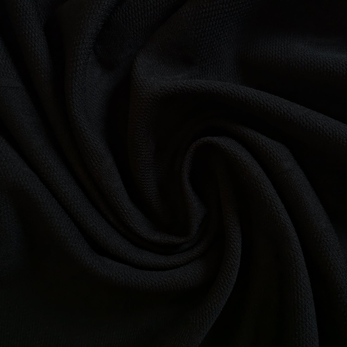 Black G*cci polyester jacquard fabric, subtly textured with an elegant drape, perfect for apparel.