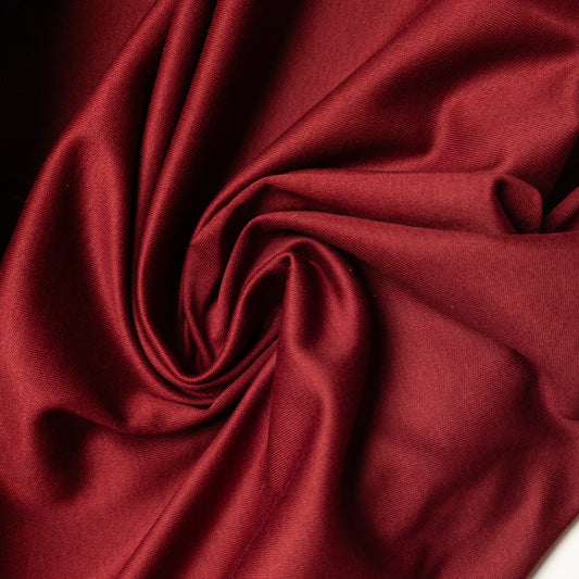 Deadstock E*ro Jersey fabric in Pantone Wine Red, draped with soft folds.